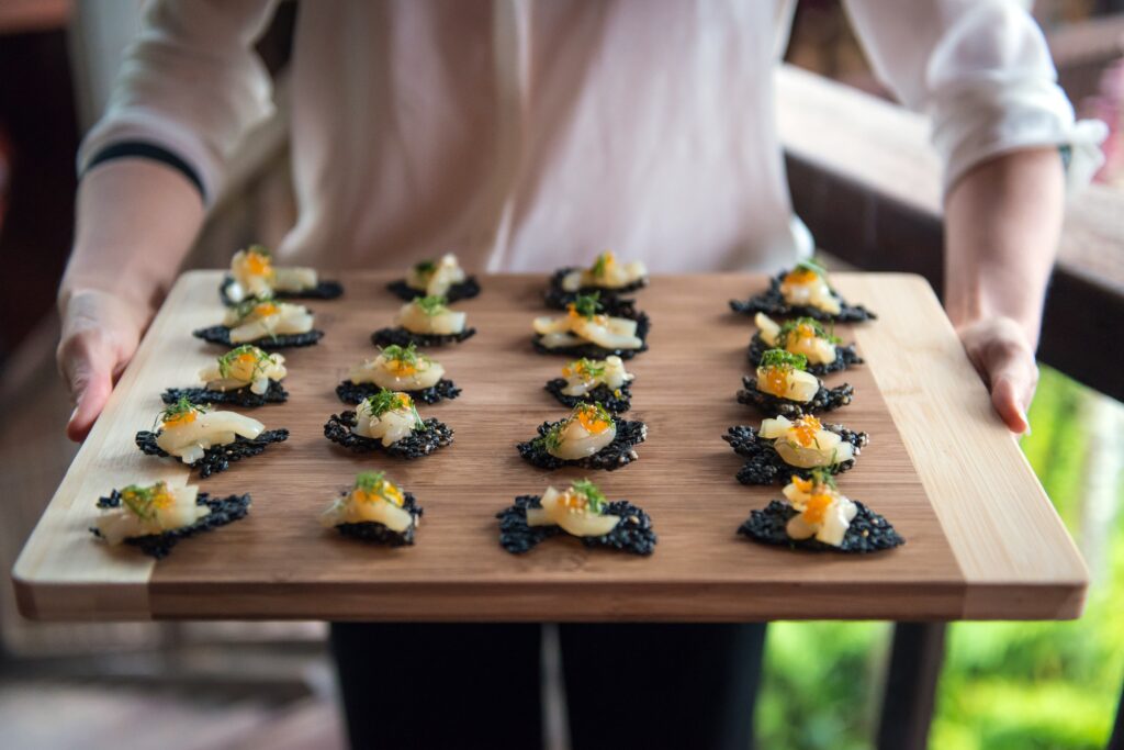 Appetizers prepared by a culinary intern, served on a wooden board, representing chef internship destinations and top countries for culinary internships.